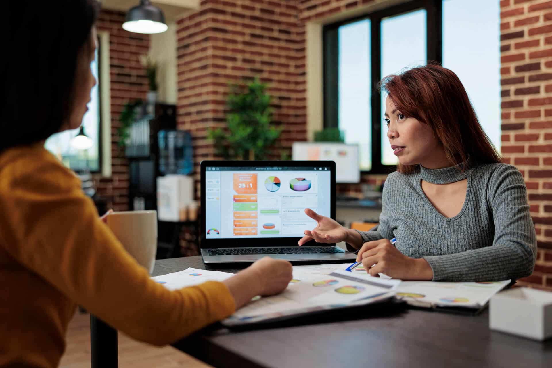 Laptop computer with marketing graphs on display standing on table | KES